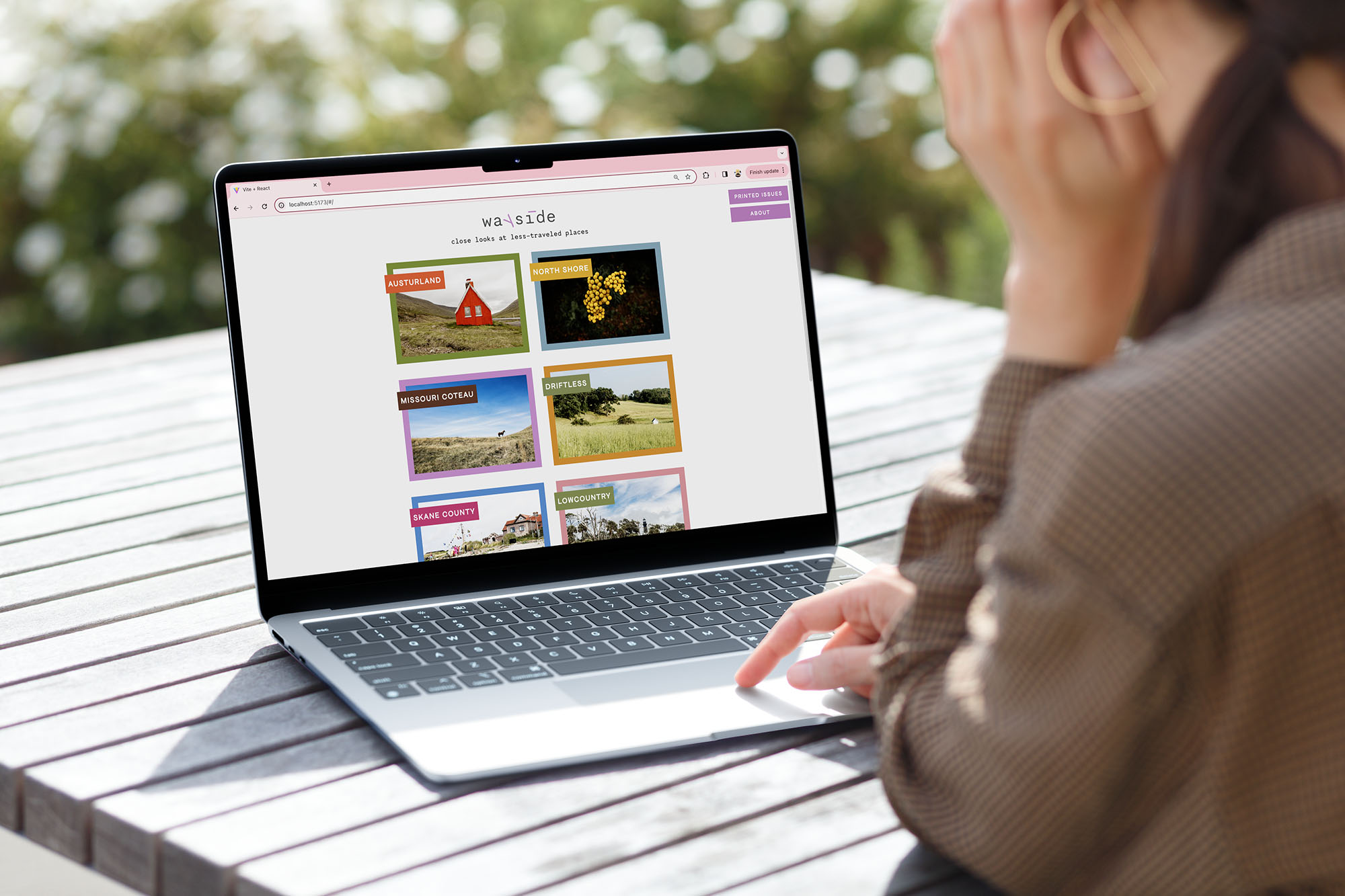 Person looking at computer screen with Wayside magazine page pulled up